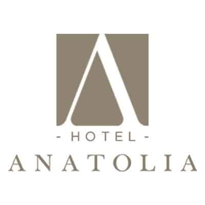 Hotel Anatolia için bir logo. Tasarım, kare bir gri-kahverengi arka plana yerleştirilmiş, gri-kahverengi renkte büyük, stilize edilmiş bir "A" harfini içeriyor. "A"nın altında, yatay çizgilerle çevrelenmiş, daha küçük büyük harflerle "HOTEL" kelimesi yazıyor. Bunun altında, daha büyük büyük harflerle "ANATOLIA" yazıyor.