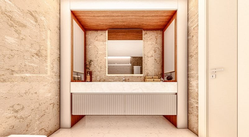 A modern bathroom features beige marble walls and a rectangular mirror bordered by wooden accents above a white countertop. The sink is centered below the mirror, flanked by organized toiletries and sleek vanity cabinets. The space is well-lit, enhancing the minimalist and clean design.