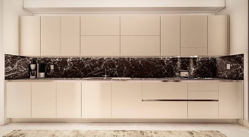 A modern kitchen featuring sleek beige cabinetry and drawers. The backsplash is a contrasting dark marble with white veins. Stainless steel appliances, including an oven and a coffee maker, are seamlessly integrated into the design. The floor appears to be tiled in a light color, enhancing the overall elegance of the kitchen storage solutions.